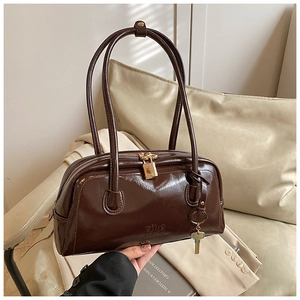 Detailed close-up of dark brown glossy bowling bag with golden lock and zipper