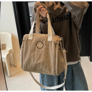 Detail of khaki canvas tote bag with drawstring closure and cute bear emblem