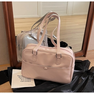 Detailed view of pink and silver glossy shoulder bags with embossed logo and front pockets