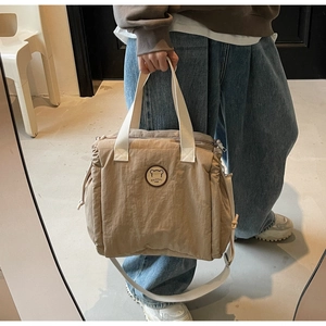 Dettagli della borsa tote in nylon kaki con tasche laterali a coulisse e logo del marchio