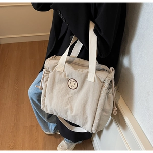 Detail of cream canvas tote bag with drawstring side and cute bear fashion patch