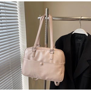 Detail of light pink faux leather tote bag with embossed logo and sturdy handles