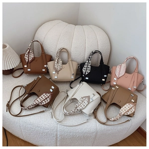 Detailed view of荔枝纹 texturized leather handbags with silk scarf handle decorations