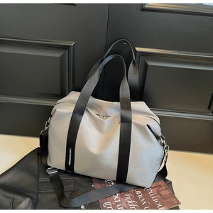 Vue détaillée du sac en nylon gris clair avec sangle noire et texte blanc