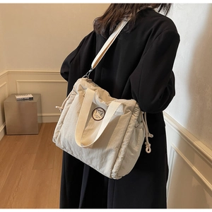Dettaglio della borsa tote in nylon beige con coulisse e toppa con logo orsetto