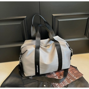Vue détaillée du sac de sport en nylon gris avec sangles lettrées et crochets en métal