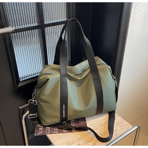 Détail du grand sac de voyage en nylon vert armée avec des sangles à lettres