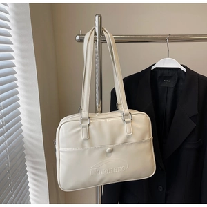 Detail of cream leather tote bag with embossed logo hanging on a hanger