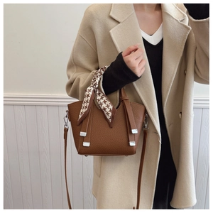 Detail of dark brown leather bucket bag with houndstooth silk scarf and silver metal accents