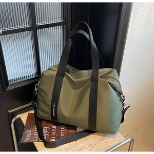 Vue détaillée du tissu en nylon vert olive avec lettrage blanc sur la bandoulière