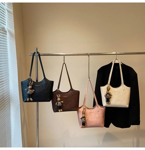 Detail of multi-color large tote bags with rabbit charms on a metal hanger