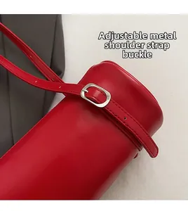 Close-up of red leather shoulder bag with adjustable silver hardware buckle strap