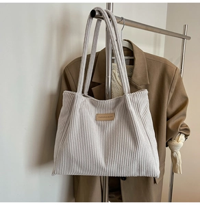 Detailed macro view of corduroy tote bag texture with brown leather fashion label