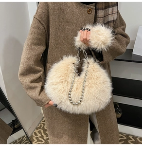 Detail of fluffy beige faux fur handbag featuring chunky silver pearl metal chain handle