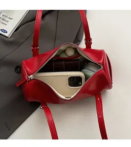 Internal storage view of red cylinder bucket bag holding phone and wallet