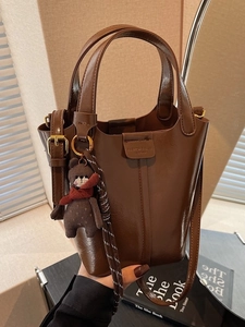 Retro dark brown leather bucket bag with top handles and cute plush bear charm accessory