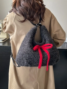 Fashionable dark grey plush tote bag with a large red bow and soft furry texture