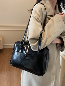 Glossy black PU leather underarm bag with embossed logo shown on a model in minimalist style