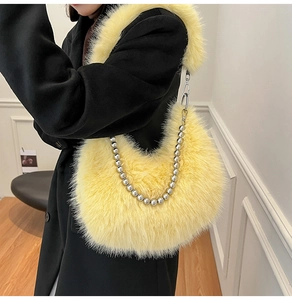 Detail of soft yellow faux fur handbag featuring a stylish silver metal bead chain strap