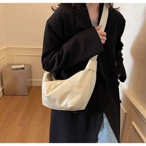 Dettaglio della borsa a mezzaluna in morbida pelle crema con design a pieghe patchwork