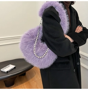 Detail of purple heart-shaped faux fur bag with silver metal chain and chunky shoulder strap