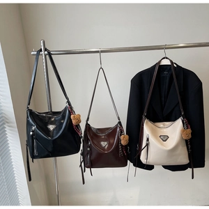 Three stylish hobo bags in black, brown and white with plush bear charm and metal logo