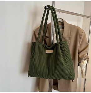 Detailed texture of olive green corduroy tote bag with fashion leather patch detail