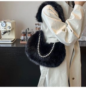 Detail of black faux fur shoulder bag with decorative pearl chain on a beige coat