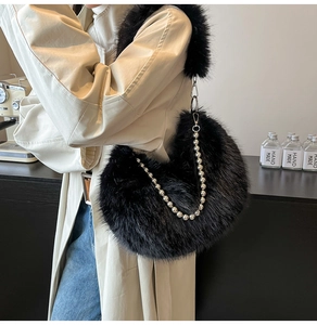 Detail of black faux fur crescent bag with decorative silver pearl chain and plush strap