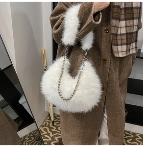 Detail of white fluffy faux fur crescent bag with decorative silver bead chain