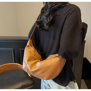 Detail of a brown PU leather dumpling bag with stylish geometric stitching for women