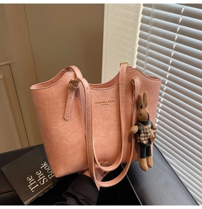 Detail of pink PU leather tote with plush rabbit charm and gold stamped fashion logo