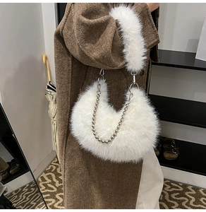 Detail of white faux fur crescent bag with polished silver bead chain and soft plush texture