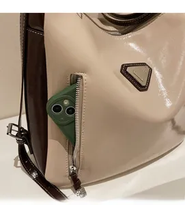 Detail of the front zipper pocket on a beige tote bag showing large capacity for a smartphone