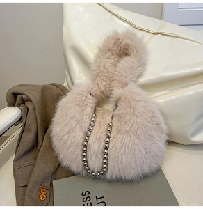 Détail d'un sac à bandoulière en peluche rose doux avec chaîne à billes argentée