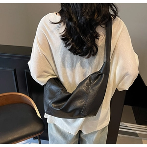 Minimalist black crescent crossbody bag shown on model for a trendy oversized fit look