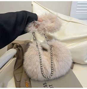 Detailed close-up of fluffy faux fur handbag with silver pearl chain and plush handle