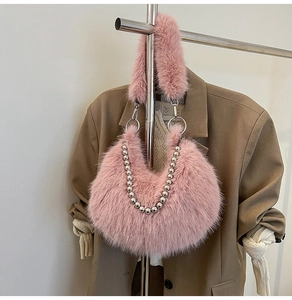 Détail du sac d'épaule en fausse fourrure rose avec chaînes à billes argentées