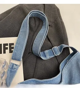Detail of adjustable blue denim strap with silver metal buckle on a large tote bag