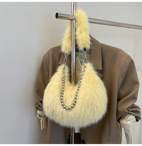 Detail of yellow faux fur hobo bag with elegant pearl chain and soft plush texture