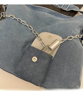 Detail of denim tote bag with silver chain and a small pouch for lipstick storage