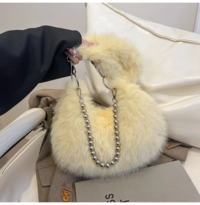 Detailed close-up of fluffy faux fur handbag featuring silver metallic bead chain and soft texture