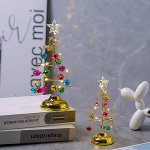 Détail de deux sapins de Noël spirale dorés avec lumières LED et clochettes colorées