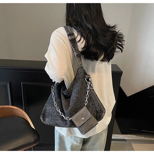 Detail of grey washed denim tote bag showing wide strap and silver chain with mini pouch