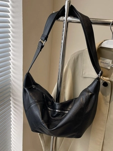 Minimalist black matte crescent crossbody bag with silver zipper and wide shoulder strap