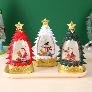 Drei Weihnachtsbaum-Schneekugeln in Rot, Weiß und Grün mit goldenem Sockel auf Tablett