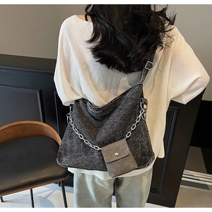 Large denim tote bag with silver chain and mini pouch shown from back view on model