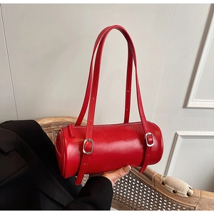 Detail of red cylinder shoulder bag with glossy leather and silver metal buckles
