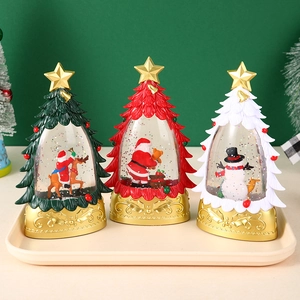 Detail von drei Weihnachts-Schneekugeln mit goldenen Sockeln und festlichen Figuren