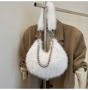 Detail of white faux fur hobo bag with a shiny silver pearl metal chain strap